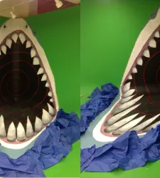 Green background, blue tissue paper and shark with mouth open